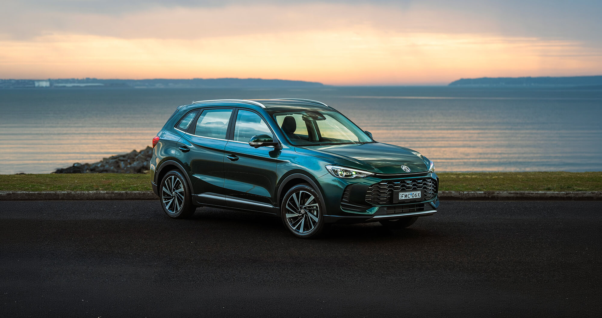 MG ZS parked in front of an ocean sunset