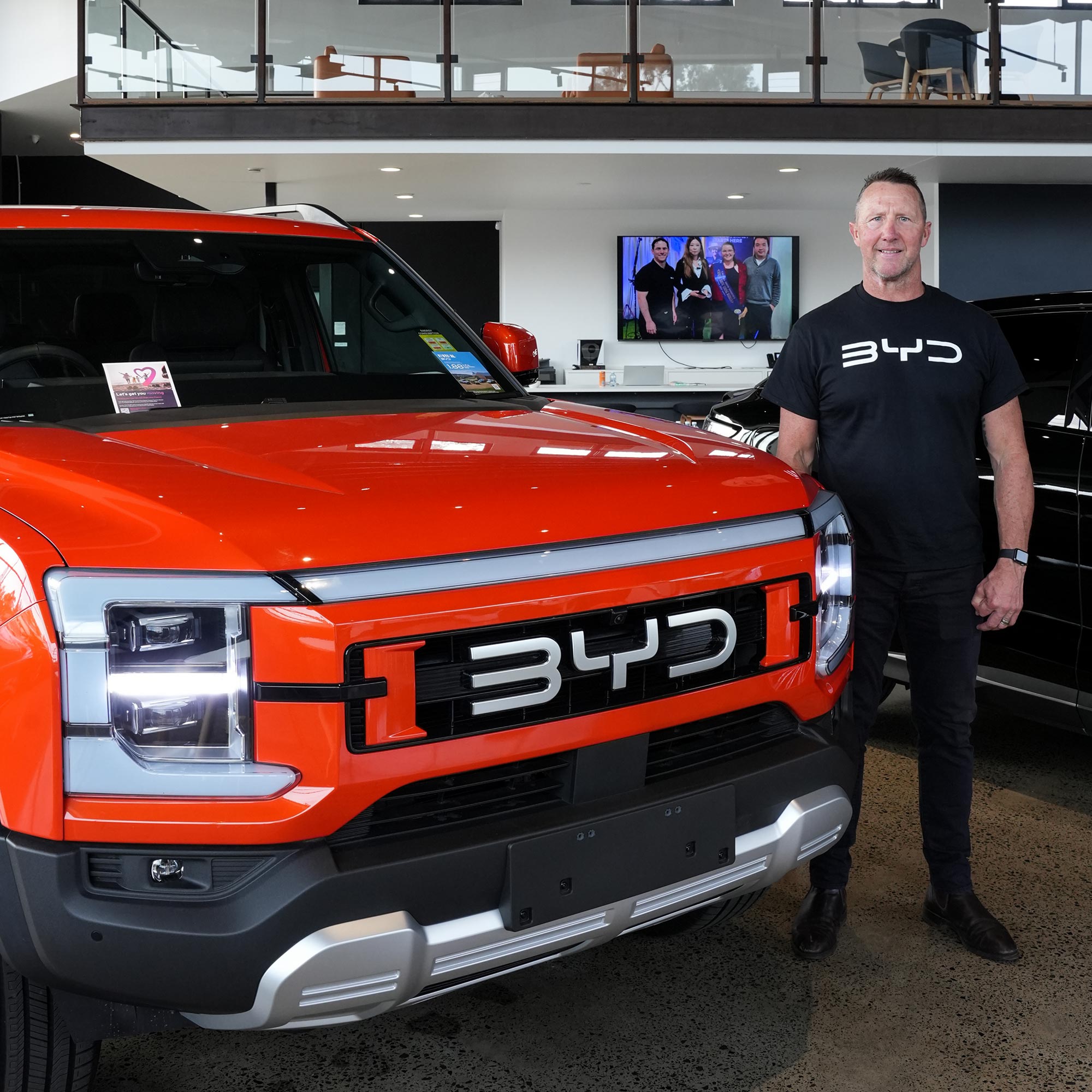 Shaun Timmo Timmins standing beside a BYD SHARK 6 in the showroom